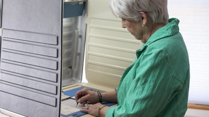 woman-voting-booth-scaled